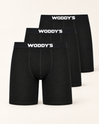 Drei schwarze Boxershorts mit langem Bein und weißem WODDY’S-Logo, versetzt vor warmem Off-White.