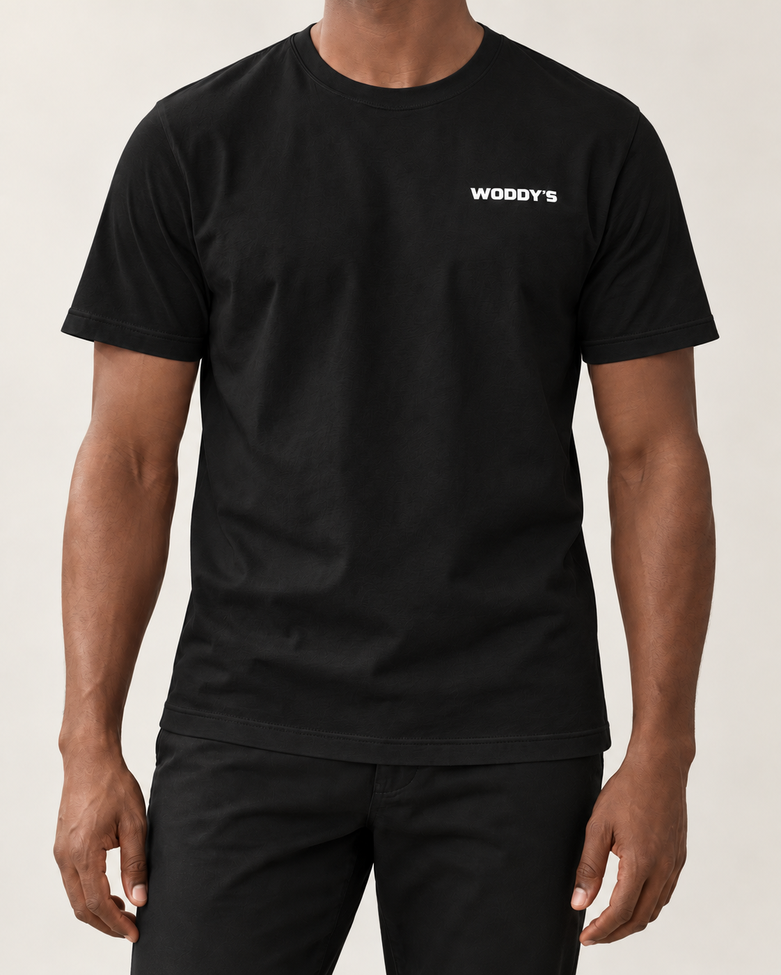 Schwarzes WODDY’S T-Shirt am Model, Ausschnitt ohne Kopf mit weißem Brustlogo